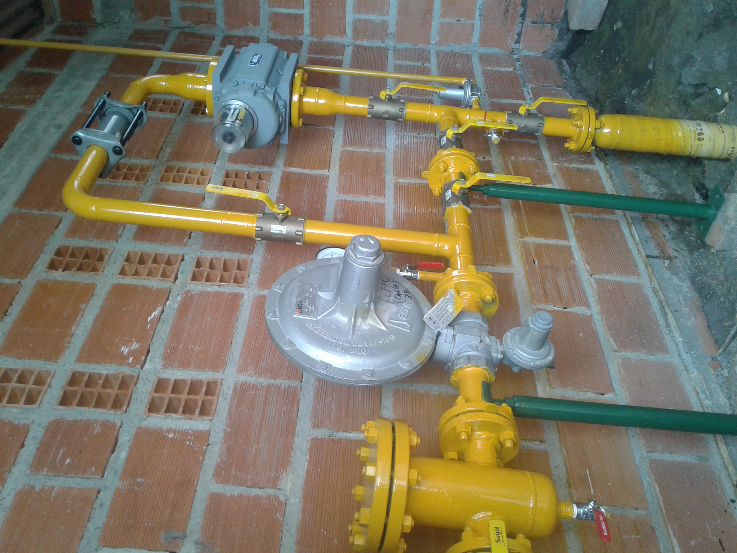 Conjunto de regulación y medición sobre pared de ladrillo